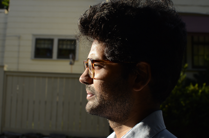 An Indian man with glasses in profile.